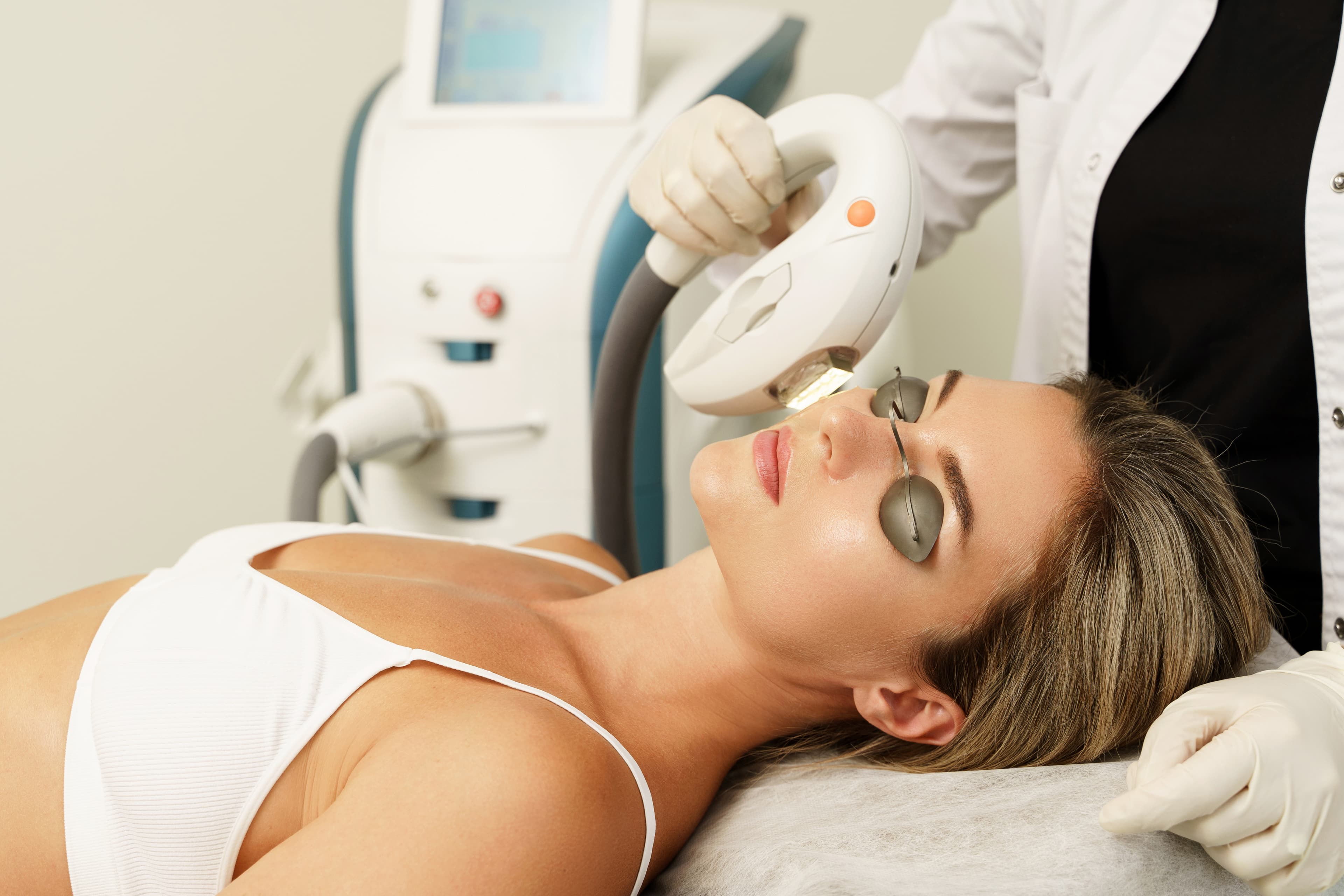 A laser skin treatment being performed on a client's face at a medspa.
